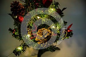 Christmas decorated small tree with red and gold decorations slowly lights up a light chain wrapped around a tree of yellow color photo