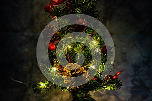 Christmas decorated small tree with red and gold decorations slowly lights up a light chain wrapped around a tree of yellow color photo