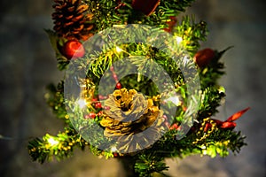 Christmas decorated small tree with red and gold decorations slowly lights up a light chain wrapped around a tree of yellow color photo
