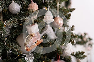 Christmas decorated tree in soft pink colors against the background of white classic fireplace with Christmas decorations. Details