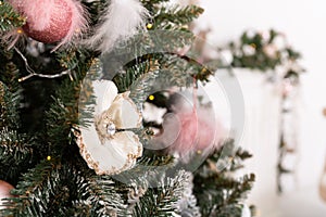 Christmas decorated tree in soft pink colors against the background of white classic fireplace with Christmas decorations. Details