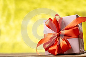 Christmas decoration on abstract  bokeh background. Merry christmas and Happy New Year Card. Gift box with red ribbon. Copy space