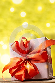 Christmas decoration on abstract bokeh background. Merry christmas and Happy New Year Card. Gift box with red ribbon. Copy space.