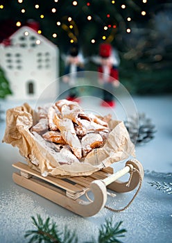 Christmas decoration with antique wooden sleigh. Freshly baked homemade cookies brushwood in the shape of a Christmas