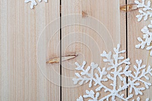 Christmas decoration background and copy space. White artificial snowflakes on a wooden table. Happy Merry Christmas and New year.