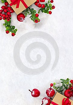 Christmas decoration, banner. Gift box with red ribbon, bow, twigs christmas tree, red berries and apples on snow