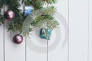 Christmas decoration baubles with branches of fir tree on wooden background