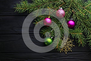 Christmas decoration baubles with branches of fir tree on wooden background