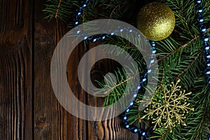 Christmas decoration baubles with branches of fir tree on wooden background