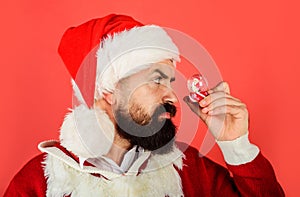 Christmas decoration. Bearded man in Santa hat with small snowglobe. Christmas snowball with little with Santa Claus