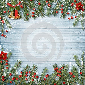 Christmas decoration with bell and holly on a wooden background