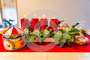 Christmas decoration with biscuits and four burning candles on an lovley advents wreath.