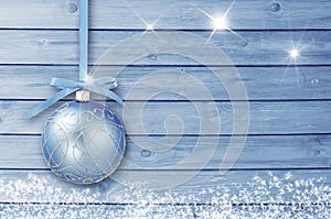 Christmas decoration on a blue wooden board with white snow, snowflakes, ice crystals. Simple Christmas, New Year card