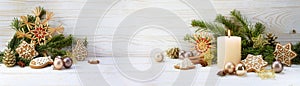 Christmas decoration and burning candle on white painted rustic wood, panoramic format with copy space