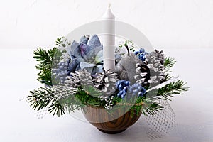 Christmas decoration with candle and blue silk poinsettias