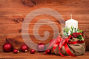 Christmas decoration - christmas composition with bag, white candle and balls on the wooden background.