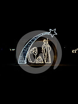 Christmas decoration of a Christmas nativity scene illuminated with lights at night