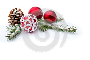 Christmas decoration. Christmas tree, red balls, cones on snow with space for text