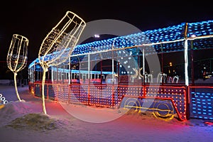 Christmas decoration of the city park with colorful lights imitating a festive train. Night shooting