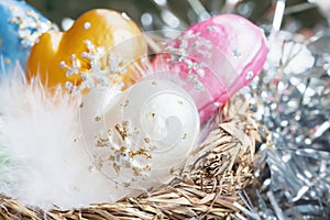 Christmas decoration from colorful decorative celluloid mittens with white bird fluff in nest