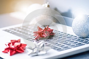 Christmas decoration on a computer. Laptop on a wooden table and white wall. Business concept during a holiday. Xmas concept.