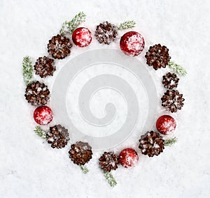 Christmas decoration. Cones pine, christmas toys and branch christmas tree on snow. Top view, flat lay