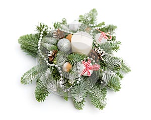 Christmas decoration consisting of fir twigs, shiny balls, cones around the candle, covered with snow on a white background, boke