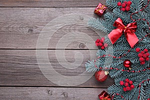 Christmas decoration. Fir-tree branch with balls, bumps, berries of viburnum and gifts on a grey background