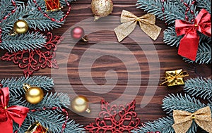 Christmas decoration. Fir-tree branch with balls, gifts and bows on a brown background