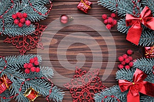 Christmas decoration. Fir-tree branch with balls, gifts and bows on a brown background