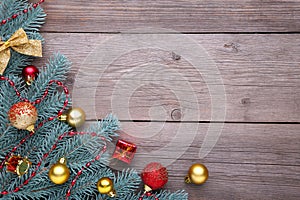 Christmas decoration. Fir-tree branch with balls, gifts and bows on a grey background