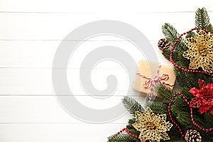 Christmas decoration. Fir-tree branch with gift and red and gold christmas flowers on white background