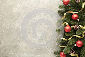 Christmas decoration. Fir-tree branch with gold balls and ribbon on grey concrete background