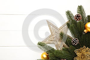 Christmas decoration. Fir-tree branch with gold star, christmas flower and balls on white