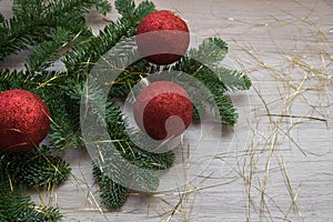 Christmas decoration. Fir tree branch and three red christmas balls.