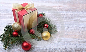 Christmas decoration fir tree with gift box and many balls, on wooden board