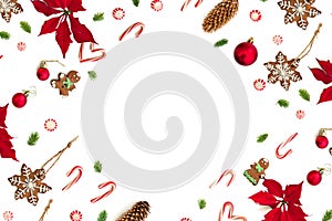 Christmas decoration. Flower of red poinsettia, christmas tree, christmas balls, gingerbread, candy canes and cones on a white