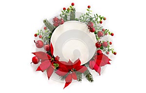 Christmas decoration. Flowers of red poinsettia, red berries, red apples, twigs christmas tree with white circle paper card note