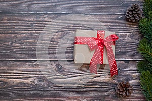 Christmas decoration, gift box and pine tree branches on wooden background, preparation for holiday concept