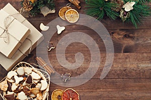 Christmas decoration, gift boxes, dry oranges, cinnamon and Christmas wreath frame background, top view with copy space