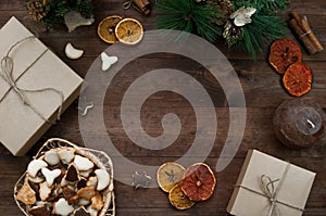 Christmas decoration, gift boxes, dry oranges, cinnamon and Christmas wreath frame background, top view with copy space