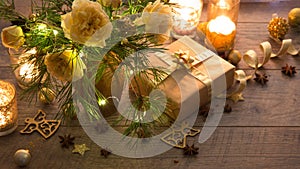 Christmas decoration. Gift, candles, lights, golden balls on a wooden rustic table. Composition of pine branches and