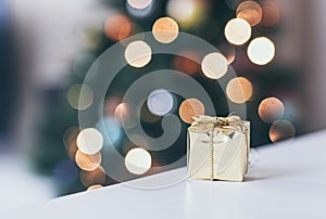 christmas decoration, golden gift and defocused lights background