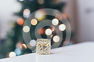 christmas decoration, golden gift and defocused lights background