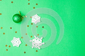 Christmas decoration on the green background. Ornaments, snowflakes, stars. Copy space