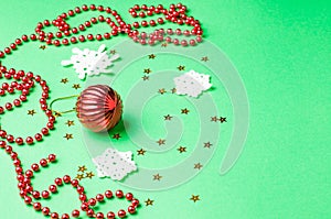 Christmas decoration on the green background. Ornaments, snowflakes, stars. Copy space