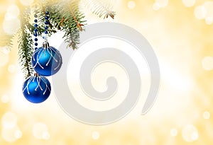 Christmas decoration. Hanging blue balls on abstract yellow golden background with space for text