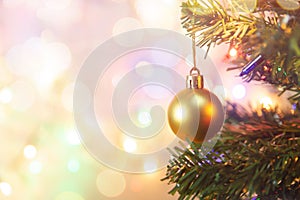 Christmas decoration. Hanging gold balls on pine branches Christmas tree garland and ornaments over abstract bokeh background with