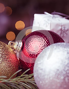 Christmas decoration. Hanging red balls on pine branches christmas tree garland and ornaments over abstract bokeh background with