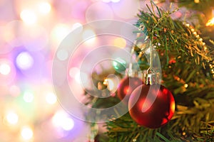 Christmas decoration. Hanging red balls on pine branches Christmas tree garland and ornaments over abstract bokeh background with